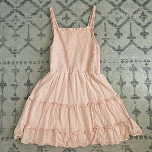 Peach colored dress with a tighter top and flare ruffle skirt.